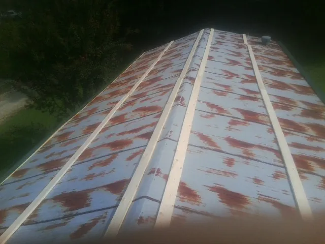 Rusted metal roof panels with new wood purlins before replacement — Storm Damage Roof Repair in Groveland by Roofing Brothers